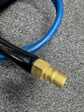 Brass fitting on a blue hose against a gray carpet background