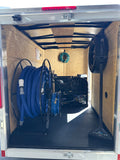 Inside view of a trailer with a hose reel and blue hose inside carpet cleaning trailer titan 375 1